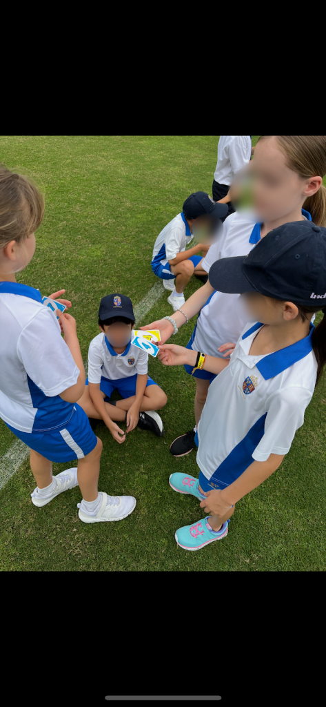 [Photo of Uno cards being used to create random groups in a Physical Education lesson]